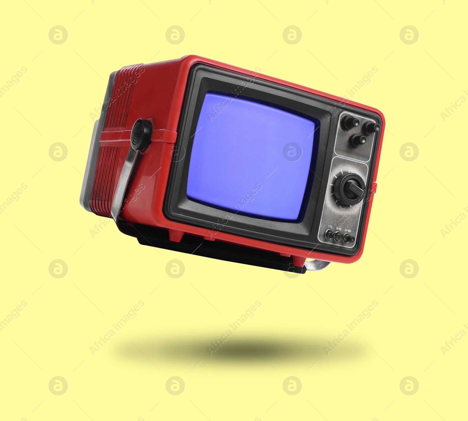 Image of Retro TV set in air on yellow background