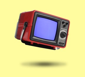 Image of Retro TV set in air on yellow background