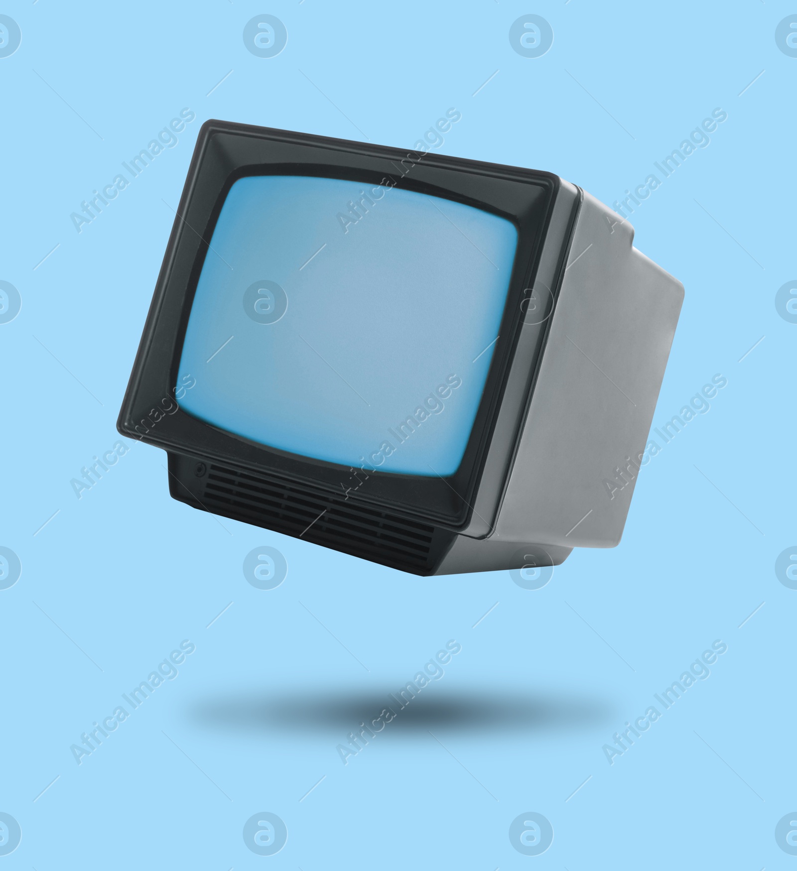 Image of Retro TV set in air on light blue background