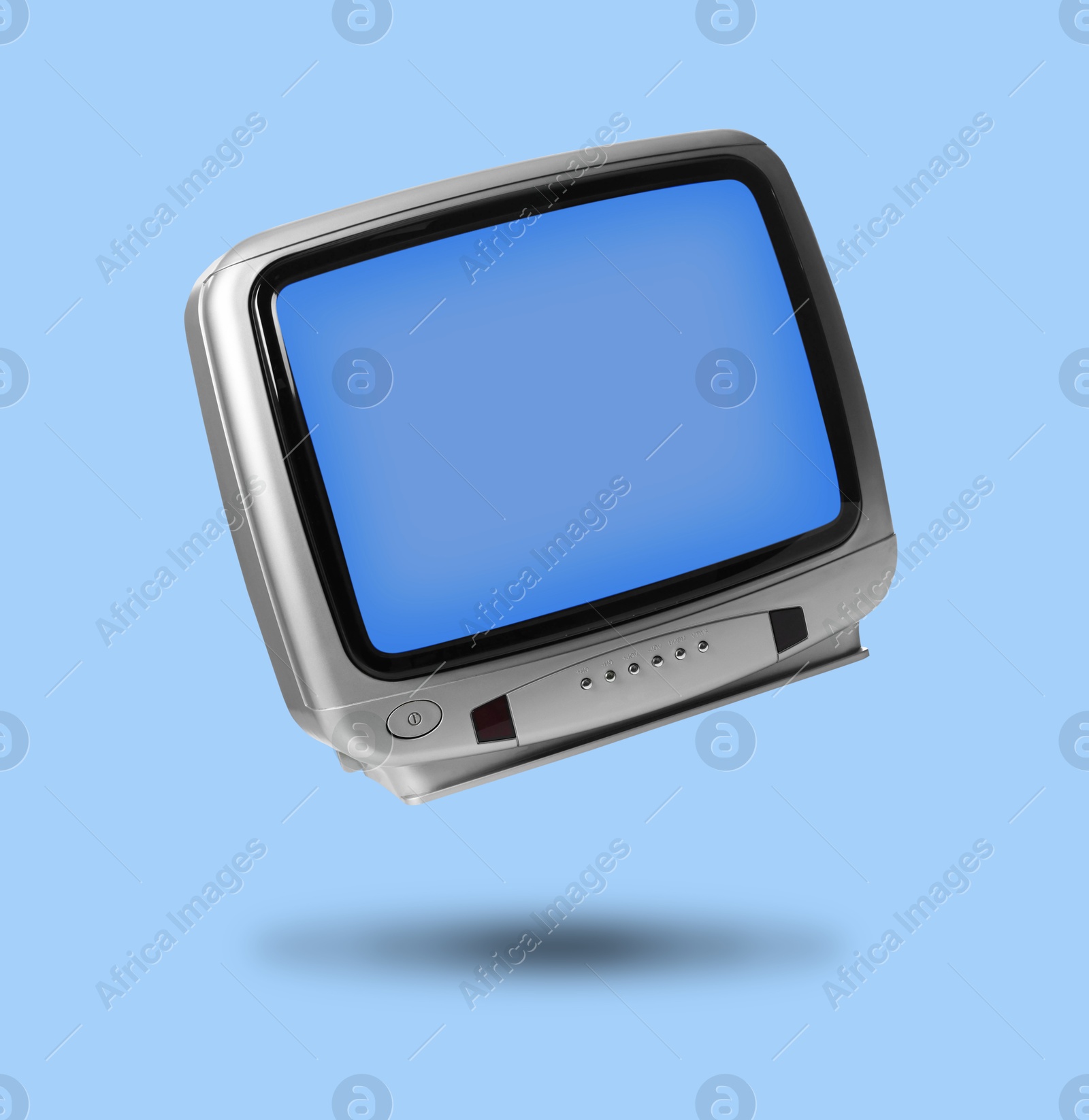 Image of Retro TV set in air on light blue background