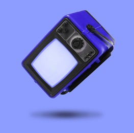 Image of Retro TV set in air on violet blue background