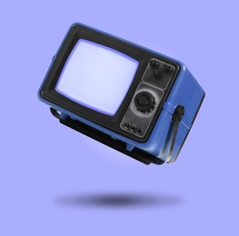 Image of Retro TV set in air on violet blue background