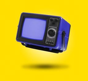 Image of Retro TV set in air on yellow background