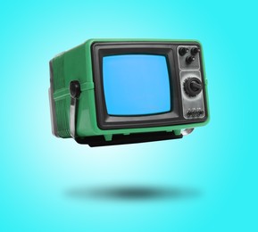 Image of Retro TV set in air on cyan color background