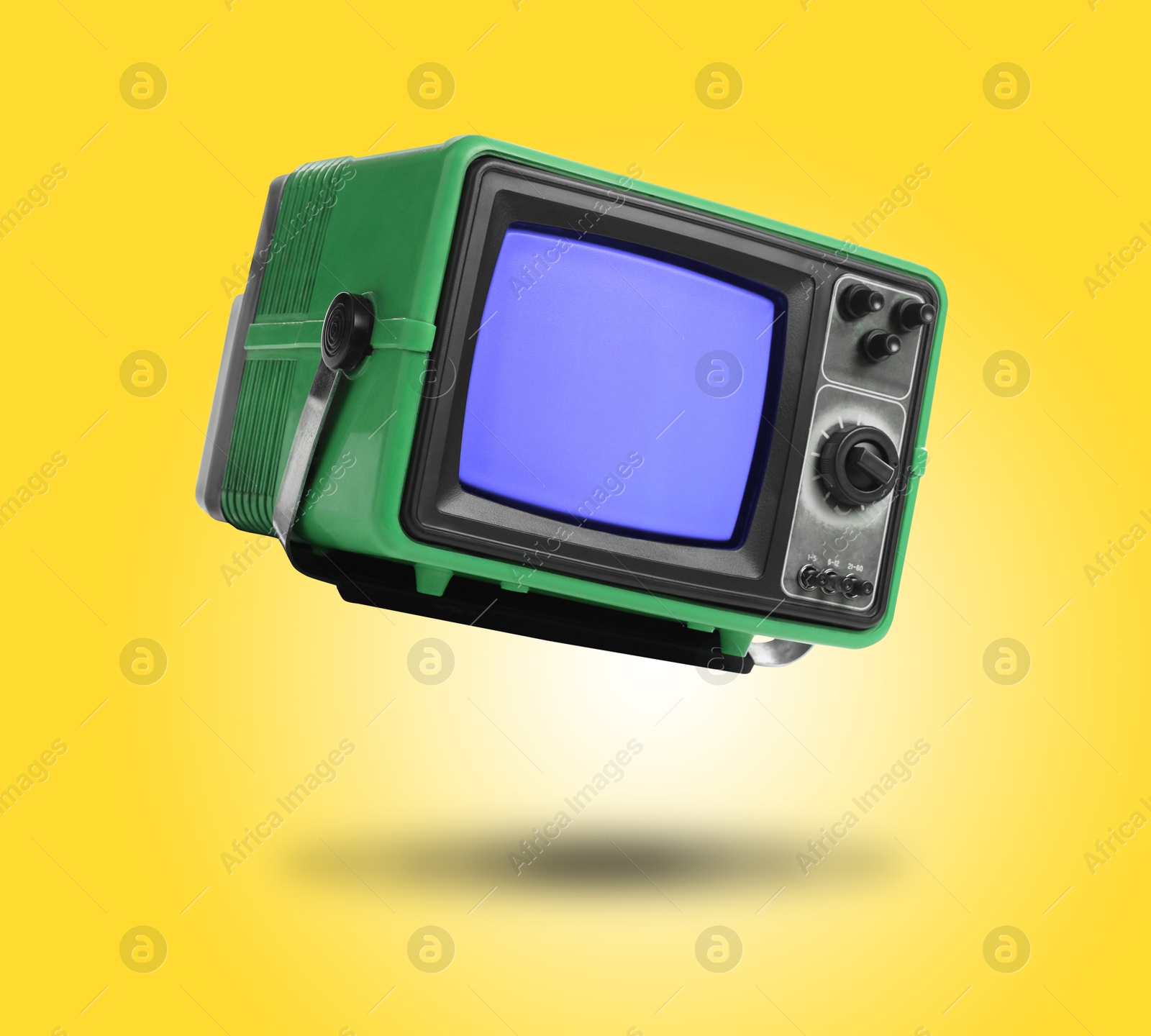 Image of Retro TV set in air on yellow background