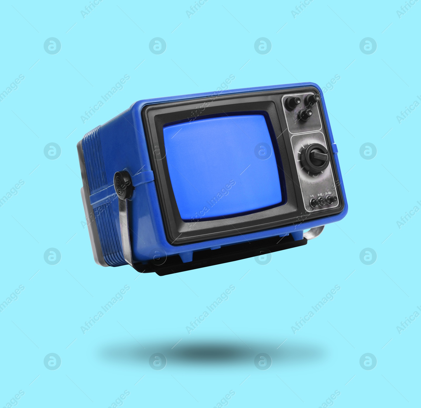 Image of Retro TV set in air on light blue background