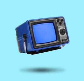 Image of Retro TV set in air on light blue background