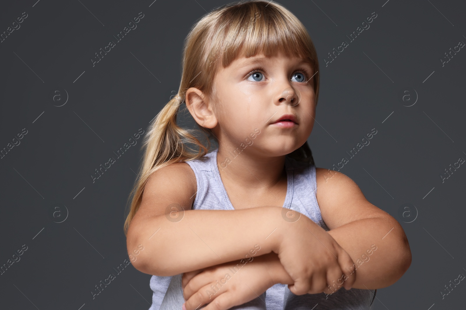 Photo of Orphanage concept. Sad little girl on grey background