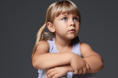 Photo of Orphanage concept. Sad little girl on grey background