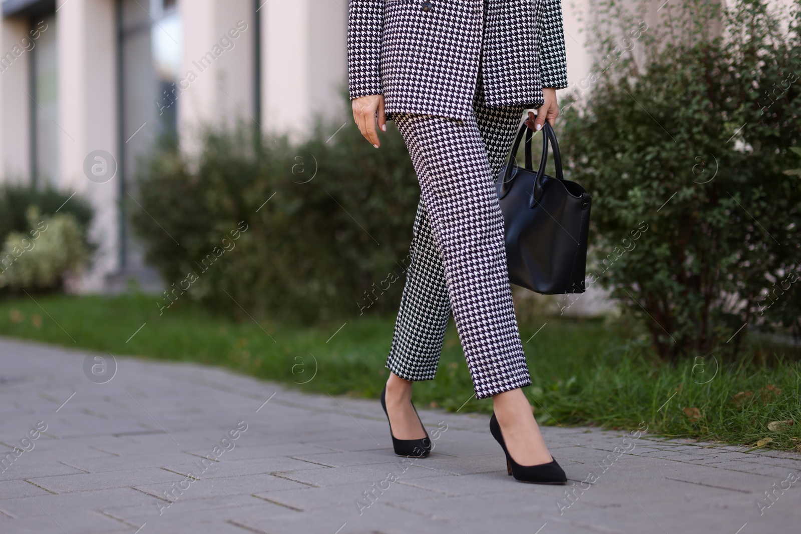 Photo of Businesswoman in stylish suit walking at work outdoors, closeup. Space for text