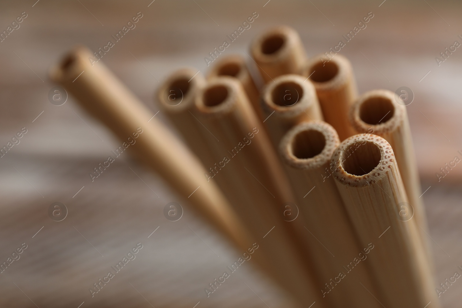 Photo of Bamboo drinking straws on blurred background, closeup