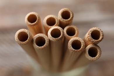 Photo of Bamboo drinking straws on blurred background, closeup