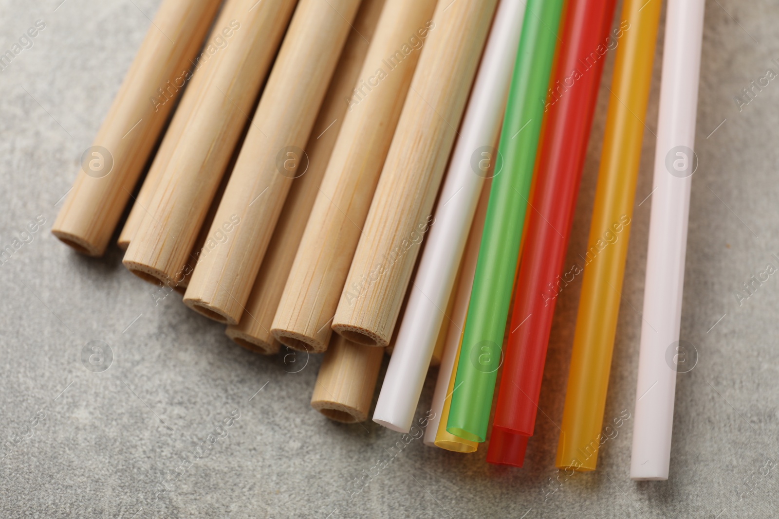 Photo of Different drinking straws on grey table, closeup