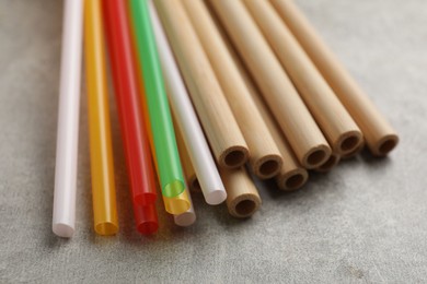 Photo of Different drinking straws on grey table, closeup