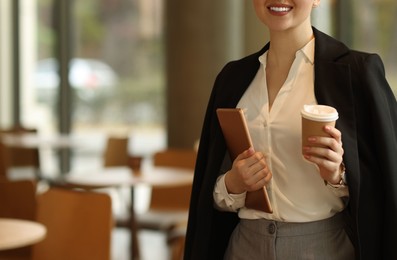 Photo of Woman in stylish formal suit with tablet and coffee indoors, closeup. Space for text