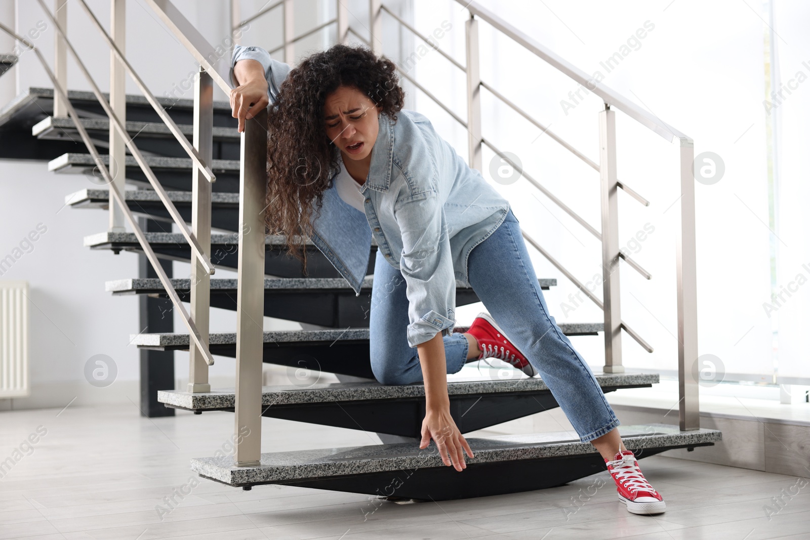 Photo of Woman falling on stairs in building. Dangerous accident