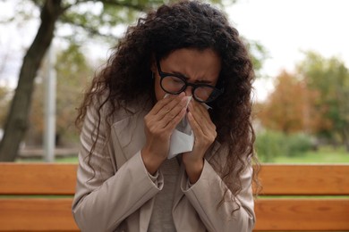 Young woman with runny nose in park