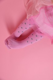 Photo of Child wearing tights on pink background, top view. Space for text