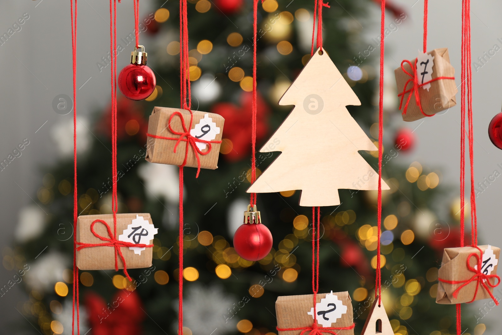 Photo of Handmade advent calendar with decor hanging near Christmas tree indoors