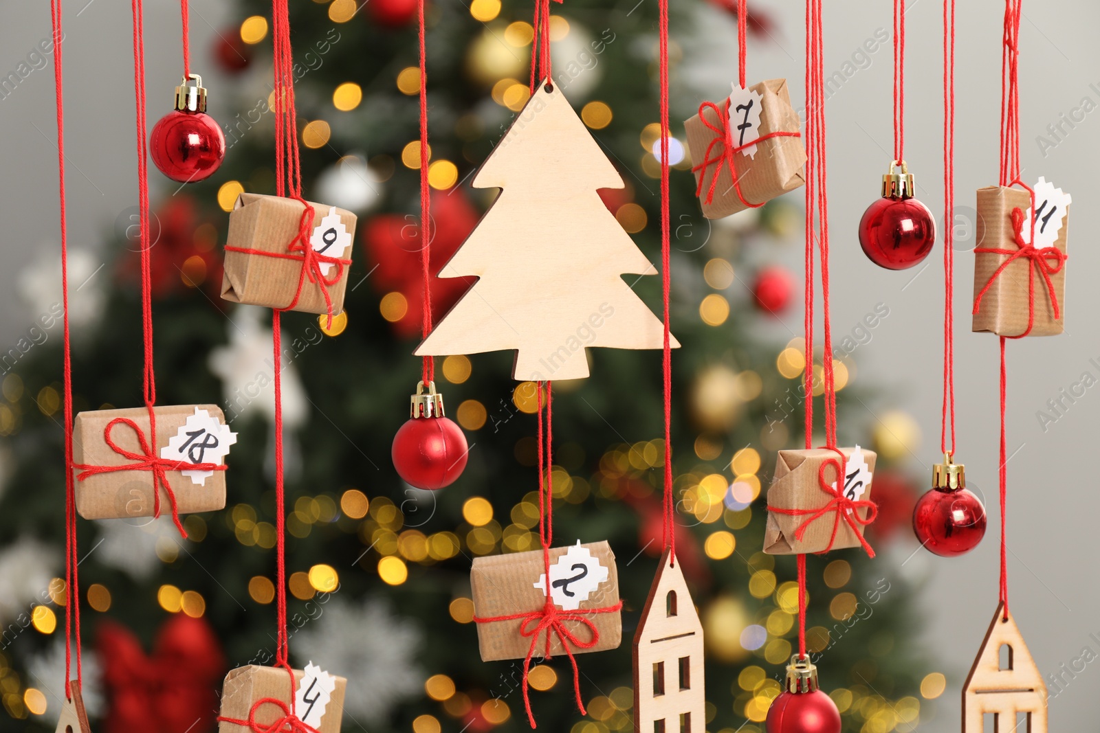 Photo of Handmade advent calendar with decor hanging near Christmas tree indoors