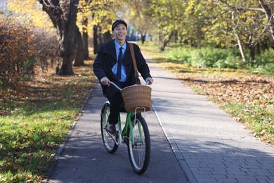 Happy mailman on bicycle outdoors. Postal service