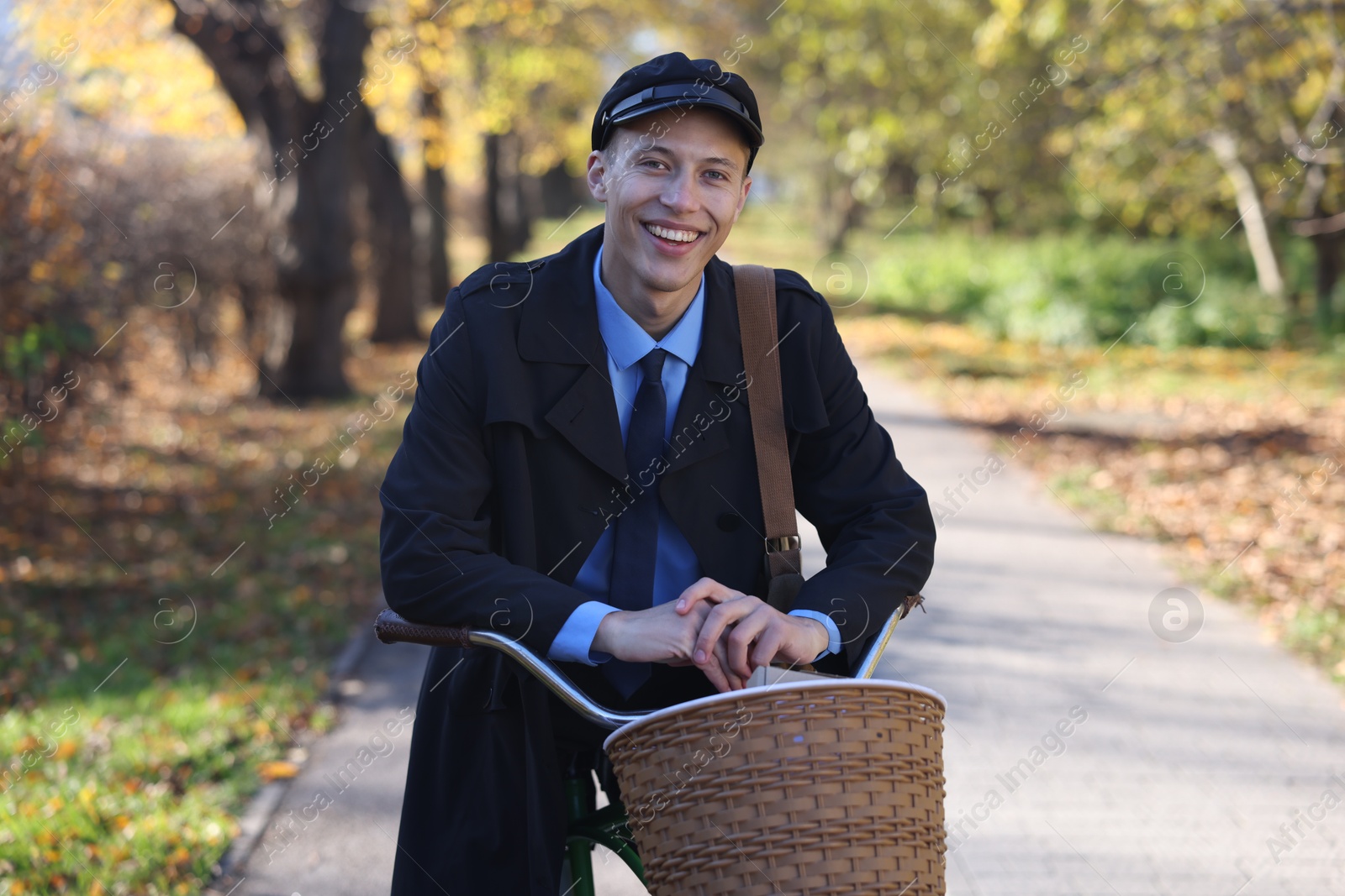 Photo of Happy mailman with bicycle outdoors. Postal service