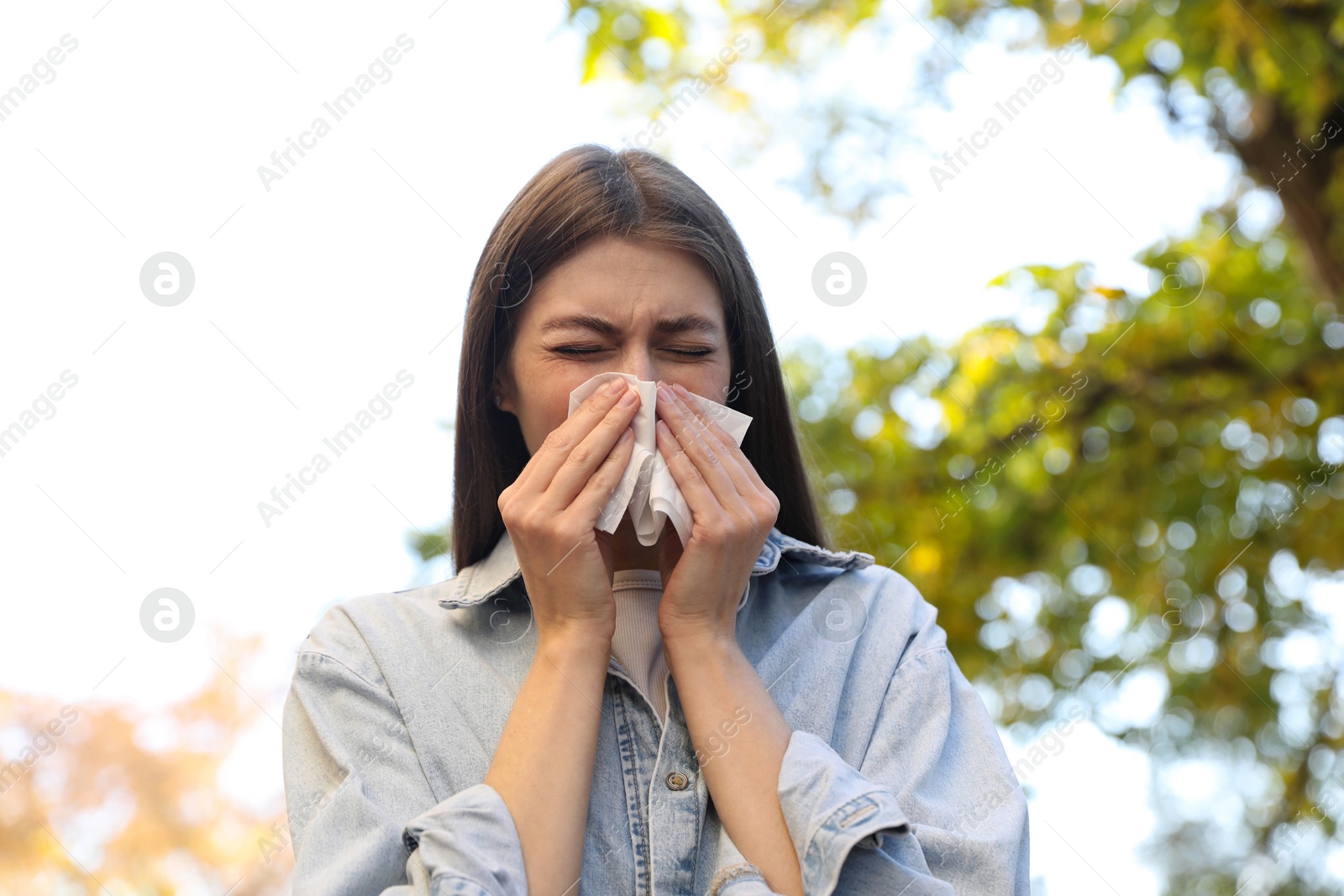 Photo of Young woman with runny nose in park