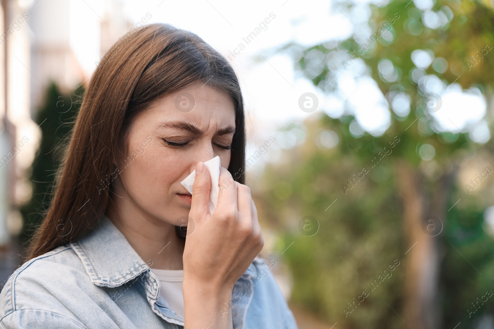 Photo of Woman with runny nose in park, space for text