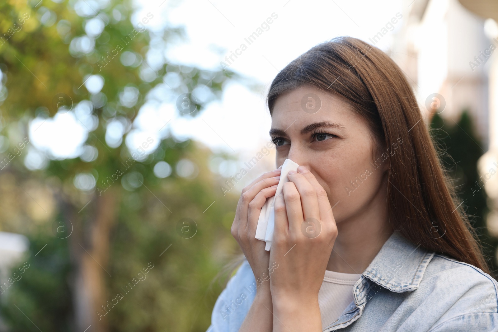 Photo of Woman with runny nose in park, space for text