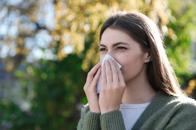 Photo of Woman with runny nose in park, space for text