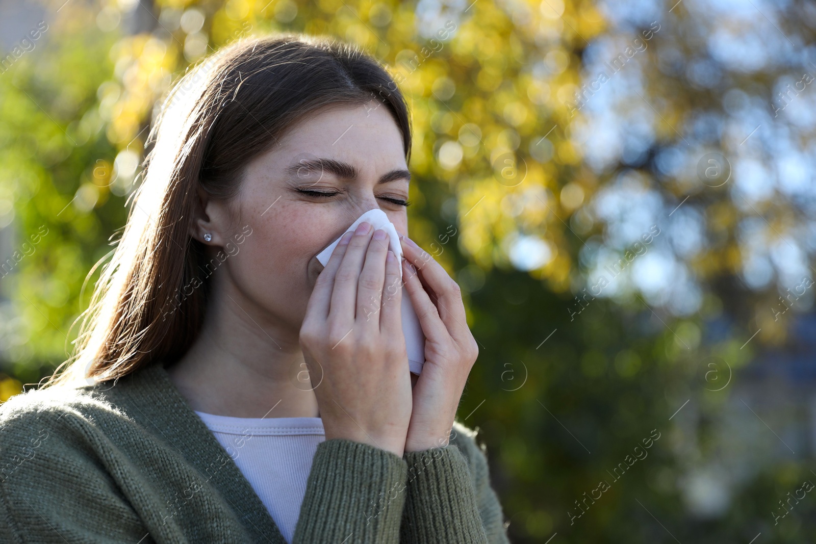 Photo of Woman with runny nose in park, space for text