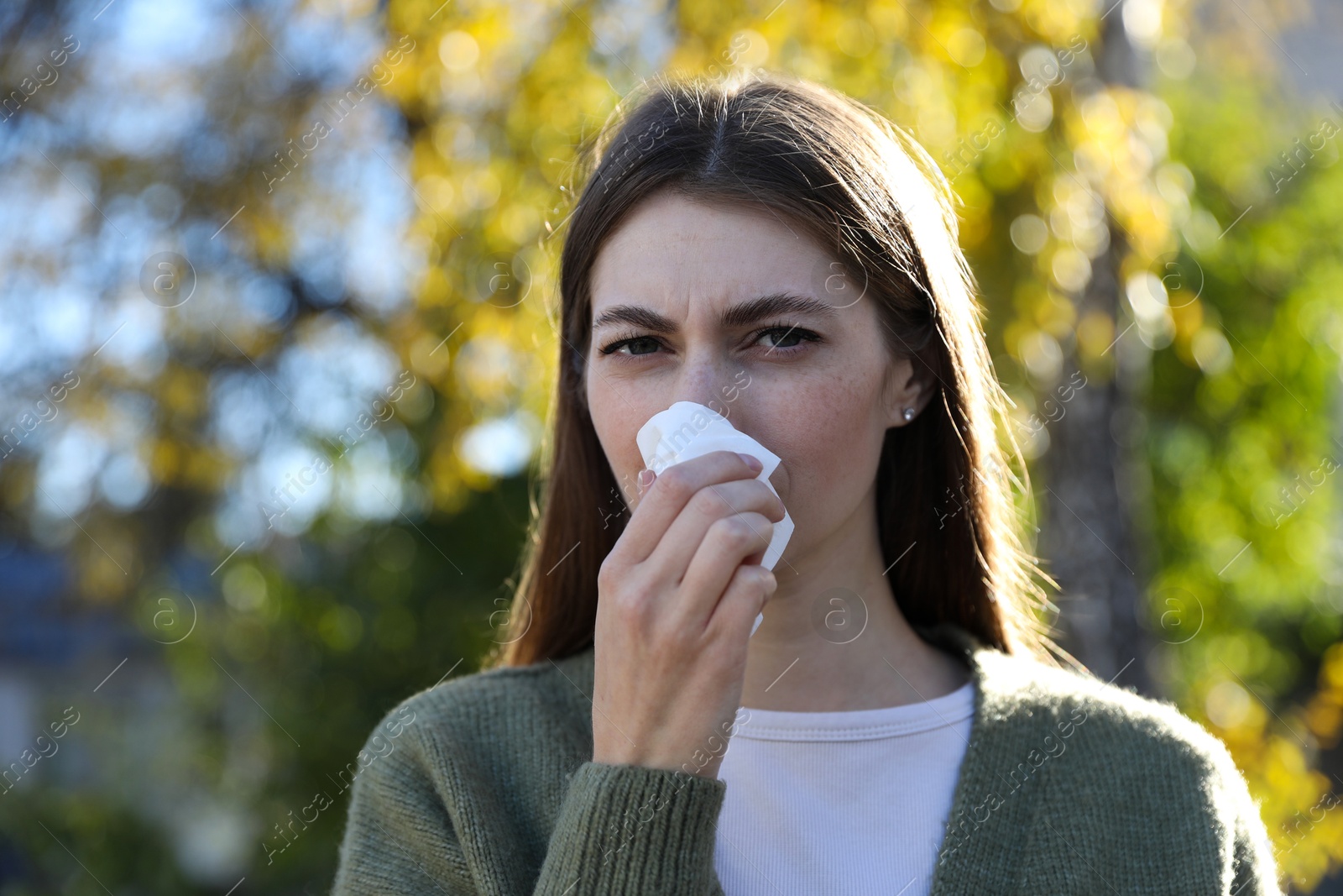 Photo of Woman with runny nose in park, space for text