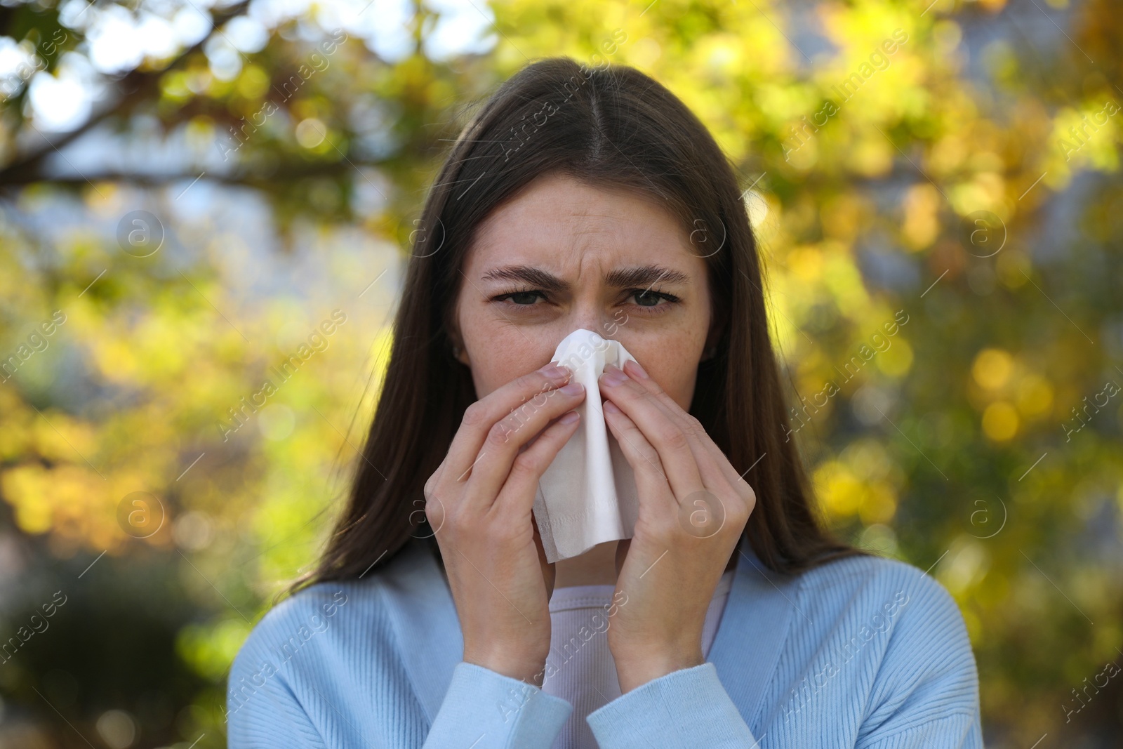 Photo of Young woman with runny nose in park