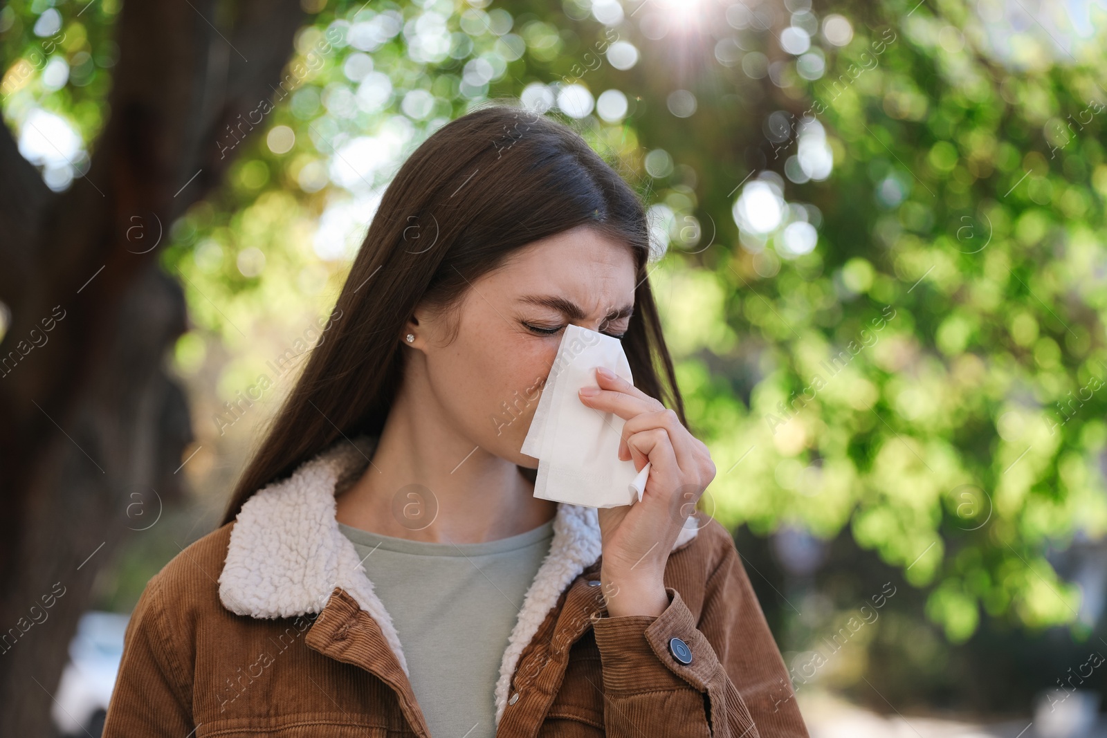 Photo of Woman with runny nose in park, space for text