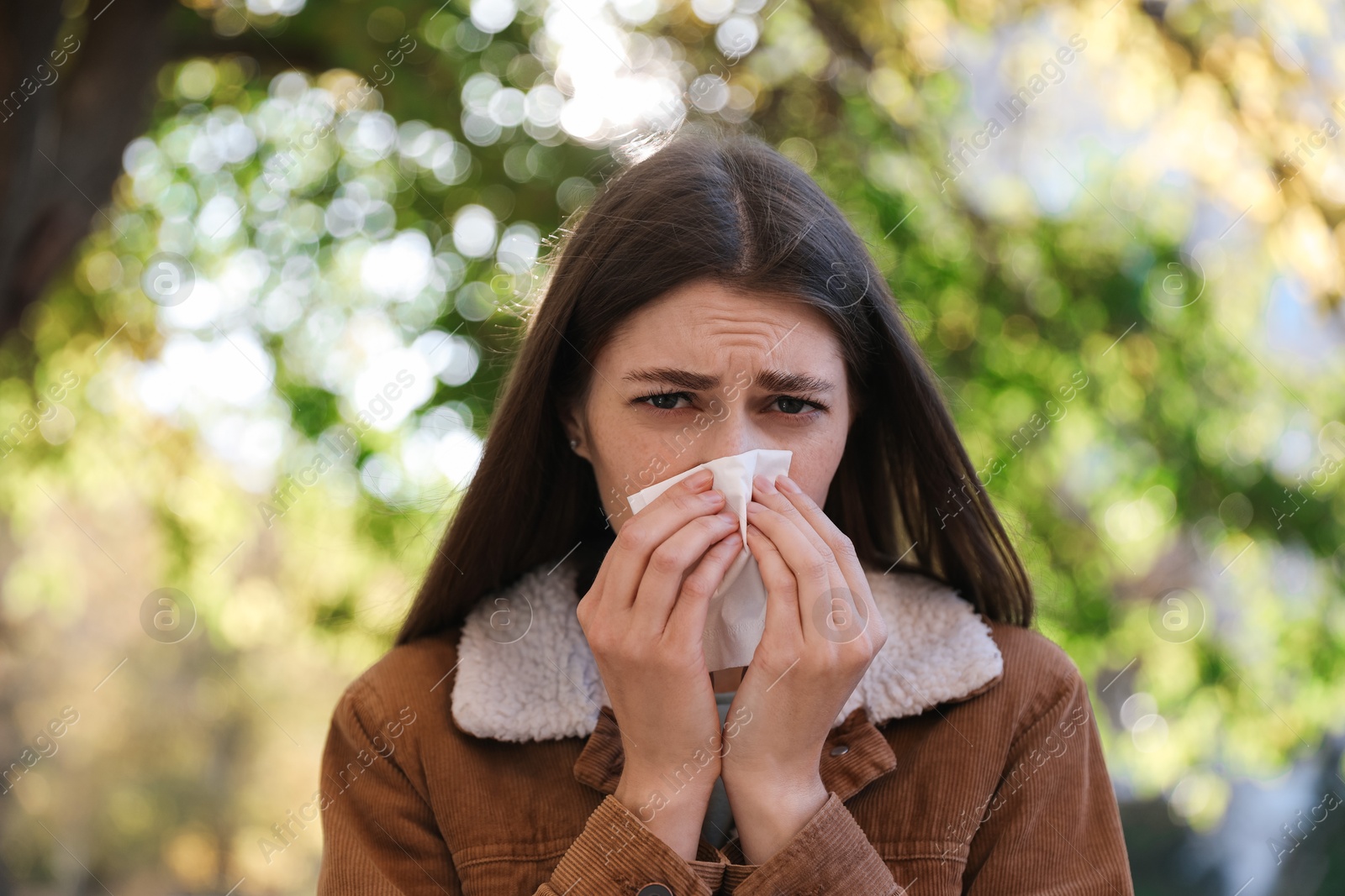 Photo of Young woman with runny nose in park