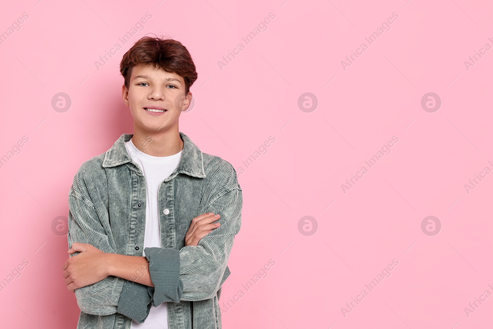 Photo of Happy teenage boy on pink background, space for text