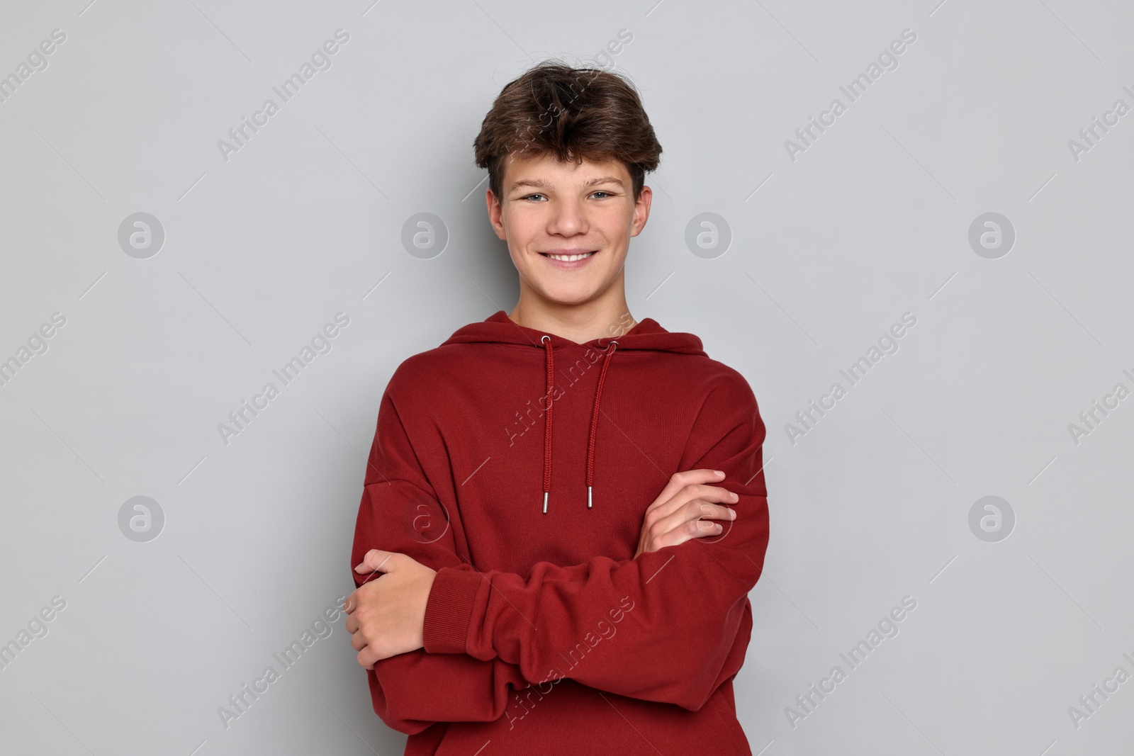 Photo of Portrait of happy teenage boy on light grey background