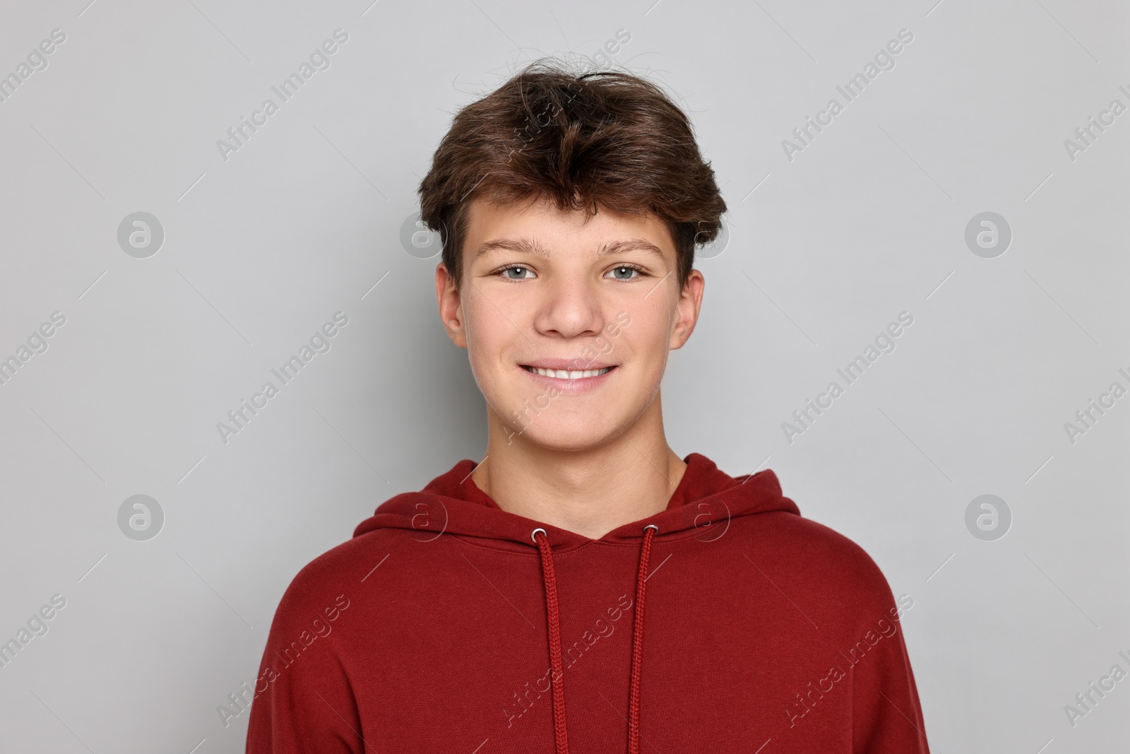 Photo of Portrait of happy teenage boy on light grey background