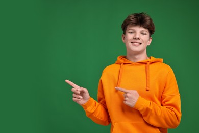 Photo of Portrait of happy teenage boy on green background, space for text