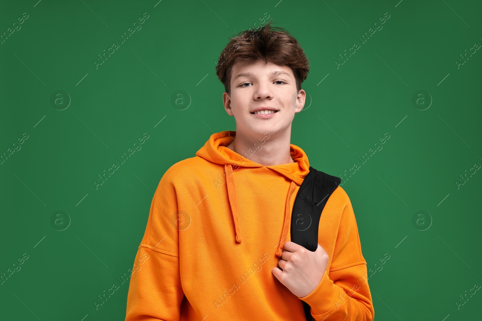 Photo of Teenage boy with backpack on green background