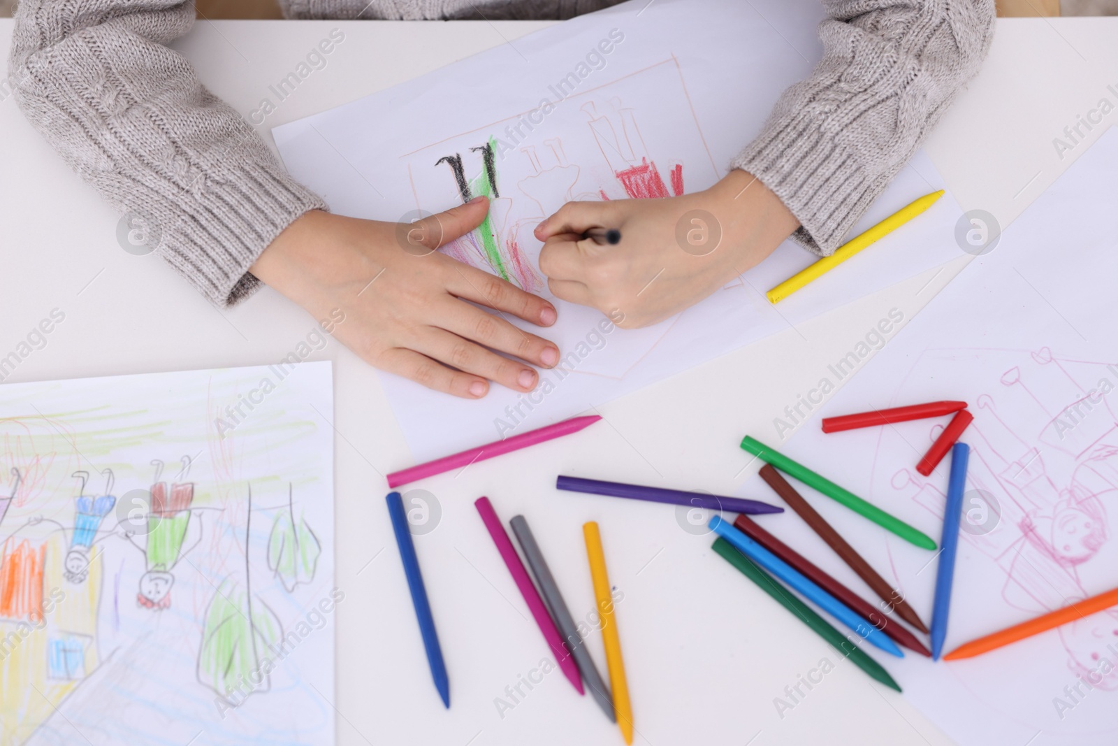 Photo of Boy drawing his family at white table, top view