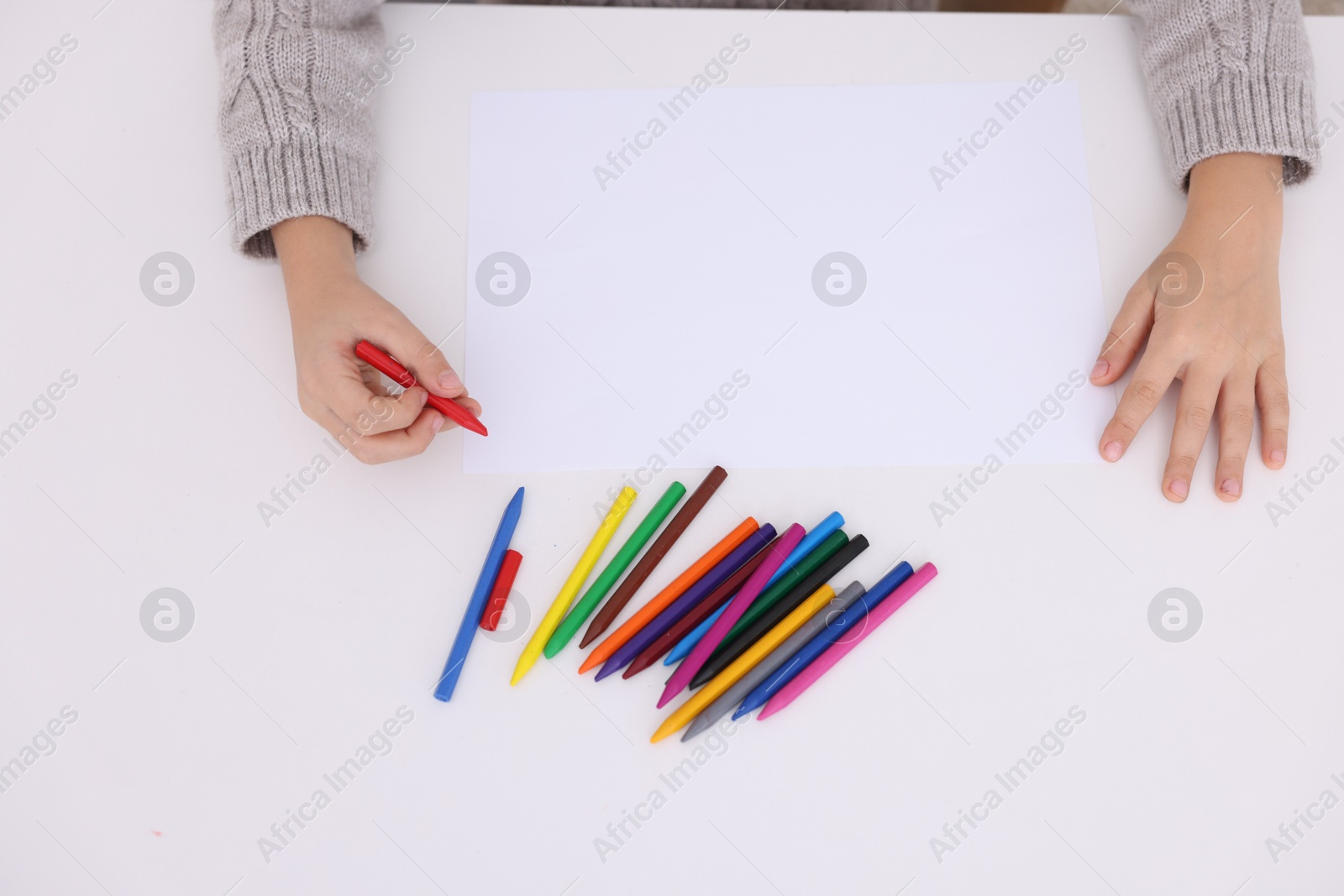 Photo of Boy drawing at white table, top view