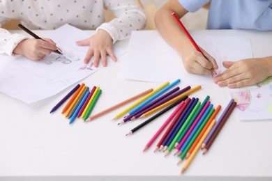 Photo of Children drawing at white table indoors, closeup