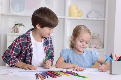 Photo of Cute children drawing at white table in kindergarten