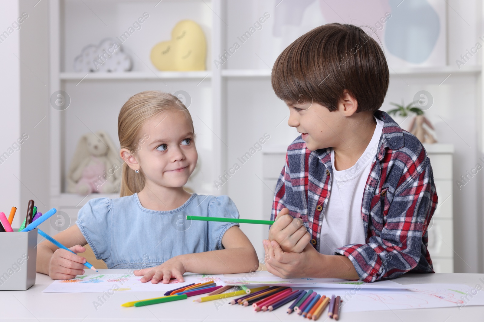 Photo of Cute children drawing at white table in kindergarten