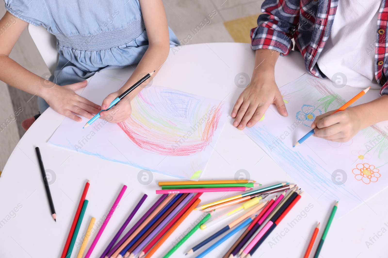 Photo of Children drawing at white table indoors, above view