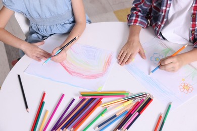 Photo of Children drawing at white table indoors, above view