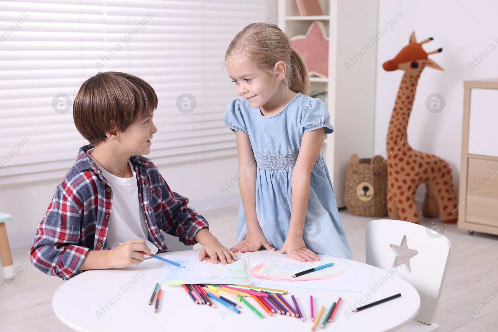 Photo of Cute children drawing at white table in kindergarten