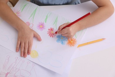 Photo of Girl drawing flowers at white table, above view