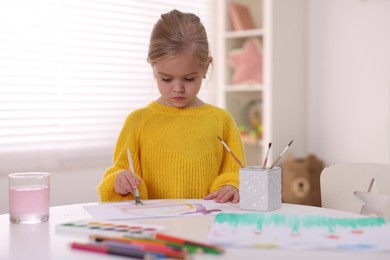 Photo of Cute girl drawing at white table in kindergarten